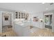Well-lit kitchen featuring white cabinets, farmhouse sink, and a breakfast bar at 115 Leaf Lake Dr, Suwanee, GA 30024