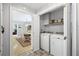 Laundry room features washer, dryer, storage and a view into the dining room at 115 Leaf Lake Dr, Suwanee, GA 30024