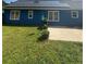 Blue home's backyard featuring a solar-paneled roof and well-maintained lawn at 160 Springdale Ct, Newborn, GA 30056