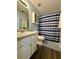Bathroom featuring a blue and white shower curtain, white vanity and cabinet, and wood-look flooring at 160 Springdale Ct, Newborn, GA 30056