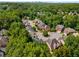 An aerial view displays a well-maintained neighborhood with tree-lined streets, distinguished homes, and lush green surroundings at 3699 Canyon Ridge Ne Ct, Brookhaven, GA 30319