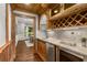 Elegant bar area featuring custom cabinetry, granite countertops, wine storage, and decorative lighting at 3699 Canyon Ridge Ne Ct, Brookhaven, GA 30319