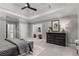 A serene bedroom features tray ceilings, a modern fan, and a stylish dresser with decor at 3699 Canyon Ridge Ne Ct, Brookhaven, GA 30319