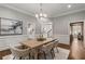 Formal dining room with modern chandelier, wainscoting, neutral colors, and hardwood floors at 3699 Canyon Ridge Ne Ct, Brookhaven, GA 30319