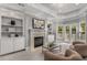 A cozy living room with fireplace, built-in shelving, and French doors to the outside at 3699 Canyon Ridge Ne Ct, Brookhaven, GA 30319