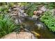 Backyard pond with koi fish, rock features, and lush greenery creating a serene oasis at 3699 Canyon Ridge Ne Ct, Brookhaven, GA 30319