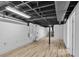 Unfinished basement features painted ceilings, wood-look floors, and access to other rooms at 6243 David Sw Ln, Mableton, GA 30126