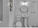 Elegant bathroom featuring a pedestal sink, new toilet, modern lighting, and white tiled shower at 6243 David Sw Ln, Mableton, GA 30126