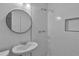 Well-lit bathroom with a modern sink, a tiled shower, and a round mirror for added style at 6243 David Sw Ln, Mableton, GA 30126