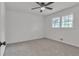 Bedroom features a ceiling fan, window, and neutral gray carpet at 6243 David Sw Ln, Mableton, GA 30126