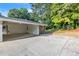 Covered carport with concrete pad extending to small brick retaining wall and backyard at 6243 David Sw Ln, Mableton, GA 30126