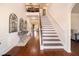 Elegant foyer with hardwood floors, staircase, and decorative console table at 817 Nevis Way, Mcdonough, GA 30253
