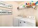 Functional laundry room with modern washer and dryer and charming decorative signs at 817 Nevis Way, Mcdonough, GA 30253