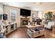 Inviting living room with a stone fireplace, large TV, stylish furniture, and hardwood floors at 817 Nevis Way, Mcdonough, GA 30253