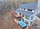 Aerial view of a modern home with a deck and a hot tub, surrounded by a vibrant forest in autumn at 2900 Orchard Sw Rd, Conyers, GA 30094
