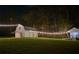 A captivating view of a white barn illuminated by charming string lights at night at 2900 Orchard Sw Rd, Conyers, GA 30094
