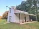 Exterior of barn featuring a white finish, barrel accents, lean-to roof, and verdant lawn at 2900 Orchard Sw Rd, Conyers, GA 30094