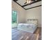 Bright bedroom with a platform bed, wood flooring, and a sliding glass door leading to outdoor access and natural light at 2900 Orchard Sw Rd, Conyers, GA 30094