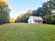 Charming white barn on a well-maintained lawn surrounded by lush trees and greenery at 2900 Orchard Sw Rd, Conyers, GA 30094