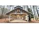 Covered outdoor event space with string lights, offering a versatile setting surrounded by tall trees at 2900 Orchard Sw Rd, Conyers, GA 30094