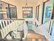 Elegant staircase with a modern chandelier, large windows offering serene views of the surrounding nature at 2900 Orchard Sw Rd, Conyers, GA 30094