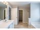 A spacious bathroom with separate bathtub, vanities, and walk-in closet at 3870 Golfe Links Dr, Snellville, GA 30039
