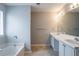 This bathroom has a large mirror and double sinks with a bathtub at 3870 Golfe Links Dr, Snellville, GA 30039