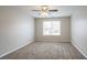 An empty bedroom with gray carpet, a window, neutral paint, and a ceiling fan at 3870 Golfe Links Dr, Snellville, GA 30039