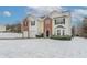 Charming two-story house with two-car garage, complemented by brick and vinyl siding, on a snow-covered lot at 3870 Golfe Links Dr, Snellville, GA 30039