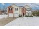 Two-story home featuring a two-car garage and a well-manicured lawn partially covered in winter snow at 3870 Golfe Links Dr, Snellville, GA 30039