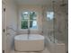 Elegant bathroom with a freestanding tub, glass-enclosed shower, and marble accents at 4955 Chamblee Dunwoody Rd, Dunwoody, GA 30338