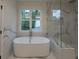Bright bathroom with a standalone tub, large windows, and marble accents at 4955 Chamblee Dunwoody Rd, Dunwoody, GA 30338