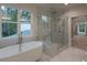 Bathroom featuring a freestanding tub, walk-in glass shower and bright windows at 4955 Chamblee Dunwoody Rd, Dunwoody, GA 30338