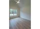 Well-lit bedroom with wood floors, a vaulted ceiling and a ceiling fan, plus a large window with backyard views at 4955 Chamblee Dunwoody Rd, Dunwoody, GA 30338