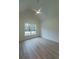 A bright bedroom with a vaulted ceiling and a large window, showcasing modern finishes and design at 4955 Chamblee Dunwoody Rd, Dunwoody, GA 30338