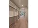 Large walk-in closet featuring custom built-in shelving, hanging rods, and hardwood floors at 4955 Chamblee Dunwoody Rd, Dunwoody, GA 30338