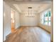 Bright, open dining room features hardwood floors, elegant chandelier, and ample natural light at 4955 Chamblee Dunwoody Rd, Dunwoody, GA 30338