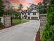 Long driveway leading up to a beautiful home featuring a gated entrance and landscaped front yard at 4955 Chamblee Dunwoody Rd, Dunwoody, GA 30338