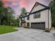 Two-story home with a gray garage door, black-trimmed windows, and a concrete driveway at 4955 Chamblee Dunwoody Rd, Dunwoody, GA 30338