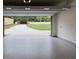 Open garage with epoxy floors showcases the driveway and beautifully landscaped backyard beyond at 4955 Chamblee Dunwoody Rd, Dunwoody, GA 30338