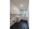 Bright laundry room featuring black marble pattern floor, sink and ample white cabinets at 4955 Chamblee Dunwoody Rd, Dunwoody, GA 30338