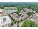 Aerial perspective of townhomes near a green athletic field, school, and commercial buildings at 565 Rose Garden Ln, Alpharetta, GA 30009