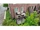 An aerial view showcases a private townhouse backyard, featuring a cozy deck, seating, and manicured shrubbery at 565 Rose Garden Ln, Alpharetta, GA 30009