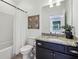 Well-lit bathroom featuring granite countertops, dark wood cabinets, and a shower-tub combo at 565 Rose Garden Ln, Alpharetta, GA 30009