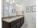 Bathroom featuring a double sink vanity with granite countertops and framed mirrors providing an elegant and functional space at 565 Rose Garden Ln, Alpharetta, GA 30009