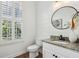 Well-lit bathroom with planked walls, granite countertop, and window providing natural light at 565 Rose Garden Ln, Alpharetta, GA 30009