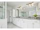 Bathroom with a double vanity, granite countertop, ample storage, and a large mirror reflecting the shower and window at 565 Rose Garden Ln, Alpharetta, GA 30009