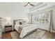 Cozy bedroom featuring a tray ceiling, plush carpet, and a large window with plantation shutters at 565 Rose Garden Ln, Alpharetta, GA 30009