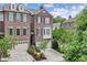 Beautiful brick townhome with a garage and bay window, surrounded by lush greenery and landscaping at 565 Rose Garden Ln, Alpharetta, GA 30009