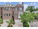 Charming brick townhome featuring well-manicured landscaping, garage, and a bay window at 565 Rose Garden Ln, Alpharetta, GA 30009